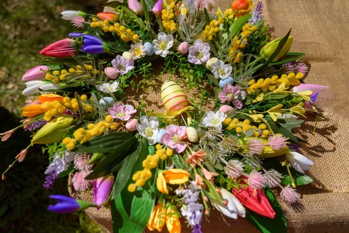 Ghirlanda floreale primaverile con mimosa e tulipani colorati, realizzata per celebrare l’8 marzo